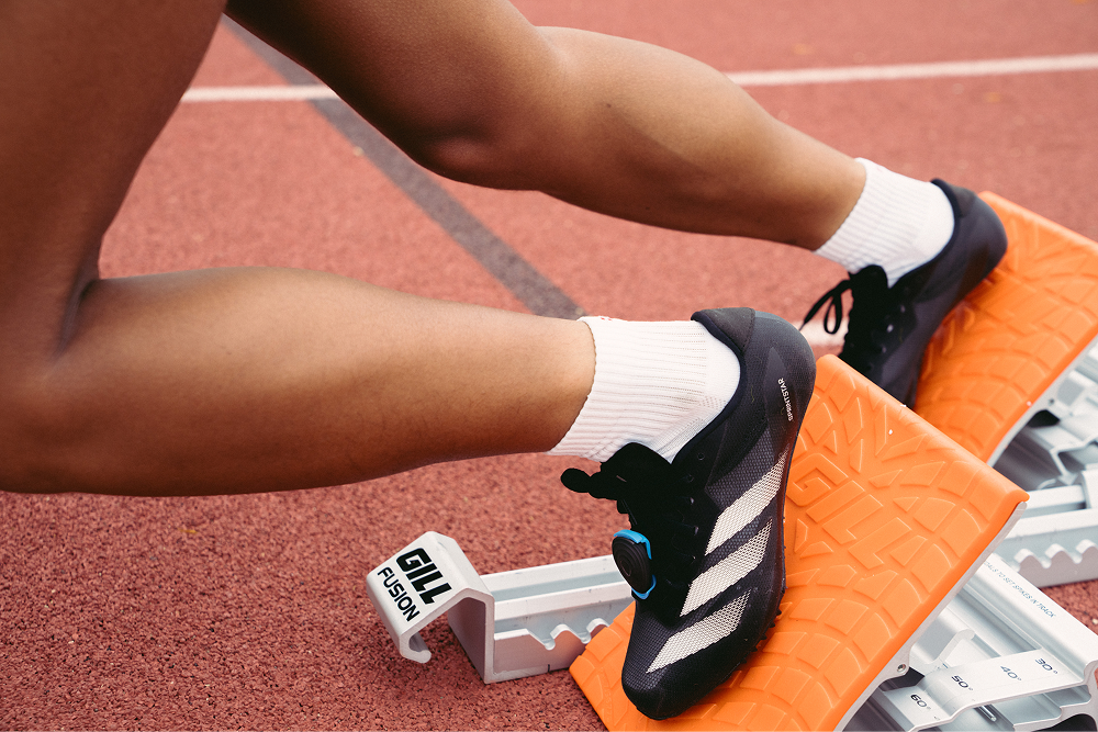 Athlete stretching at the hurdle wearing Stryd Speed