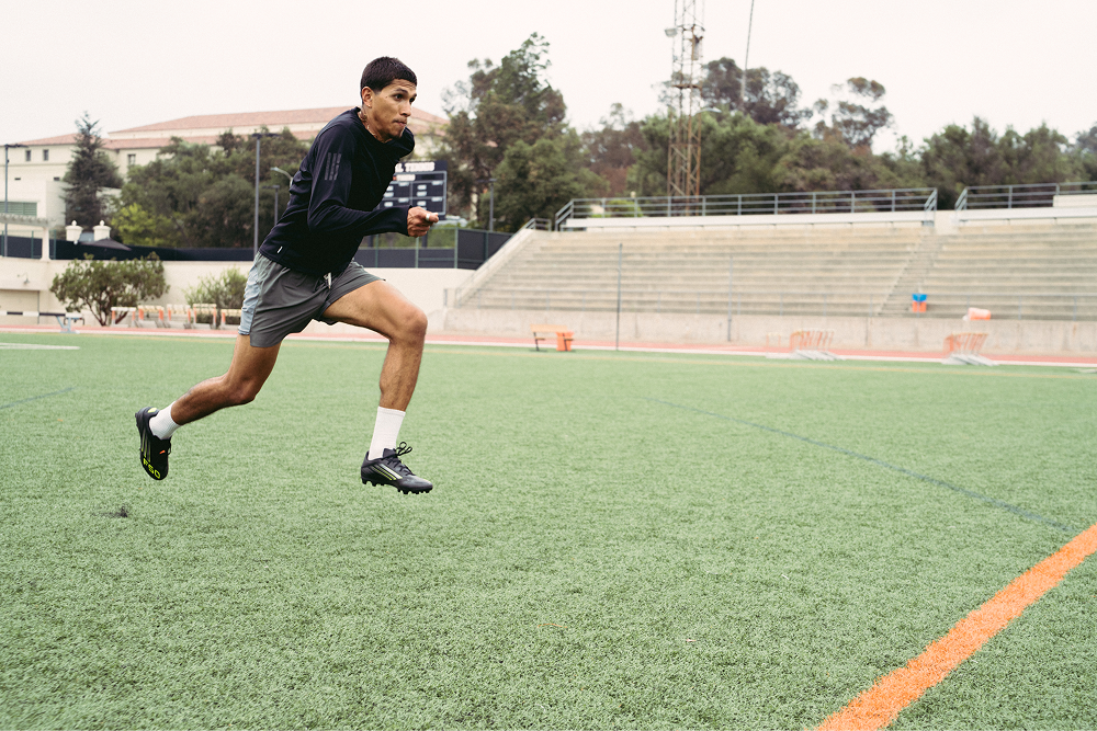 Athlete accelerating on turf wearing Stryd Speed